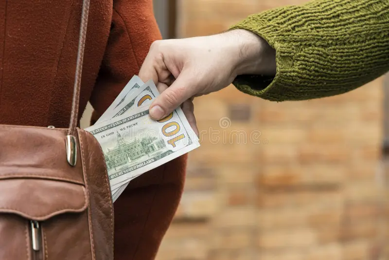 robar-dinero-de-la-bolsa-mujer-ropa-moda-y-mano-masculina-con-dólares-concepto-efectivo-calle-del-bolso-hombre-el-en-foto-175826257